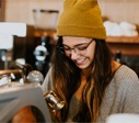 smiling hipster with beanie and round glasses