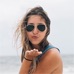 Long haired girl with sunglasses blowing a kiss at the camera, commenter.